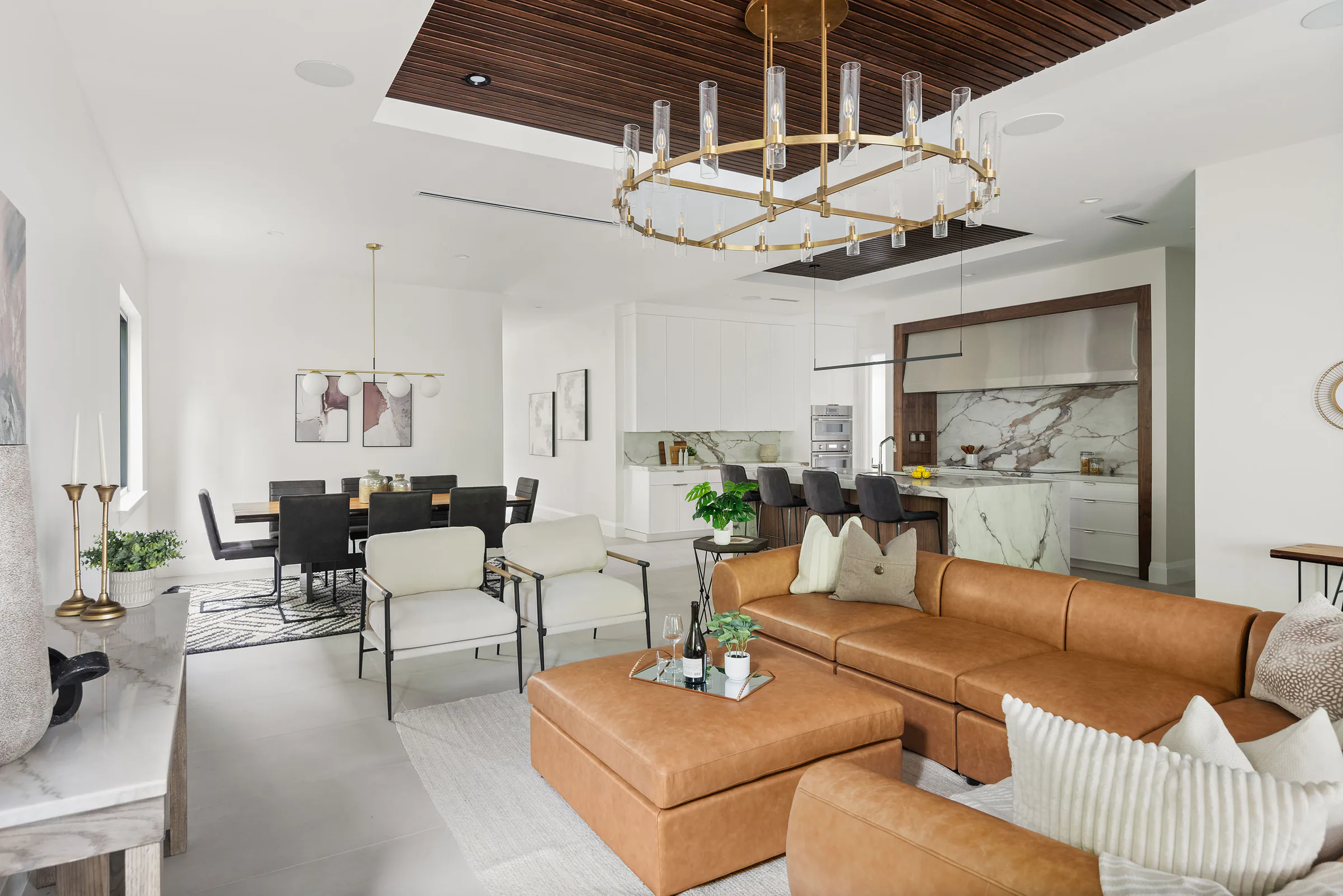 Living room with tan leather seating and bright white walls. New Hampshire, a custom home by Rare Builders in Orlando.