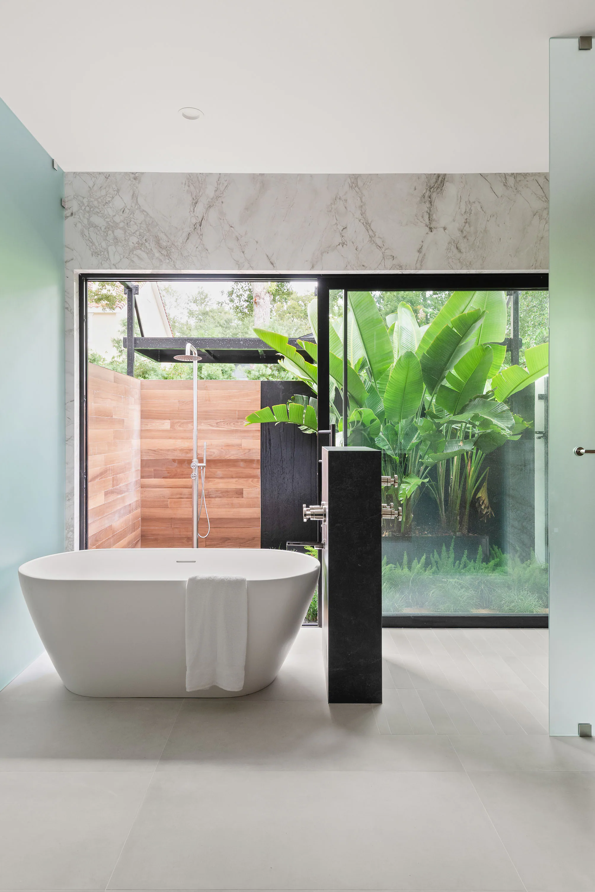 Freestanding tub beside a full-height garden window. New Hampshire, a custom home by Rare Builders in Orlando.