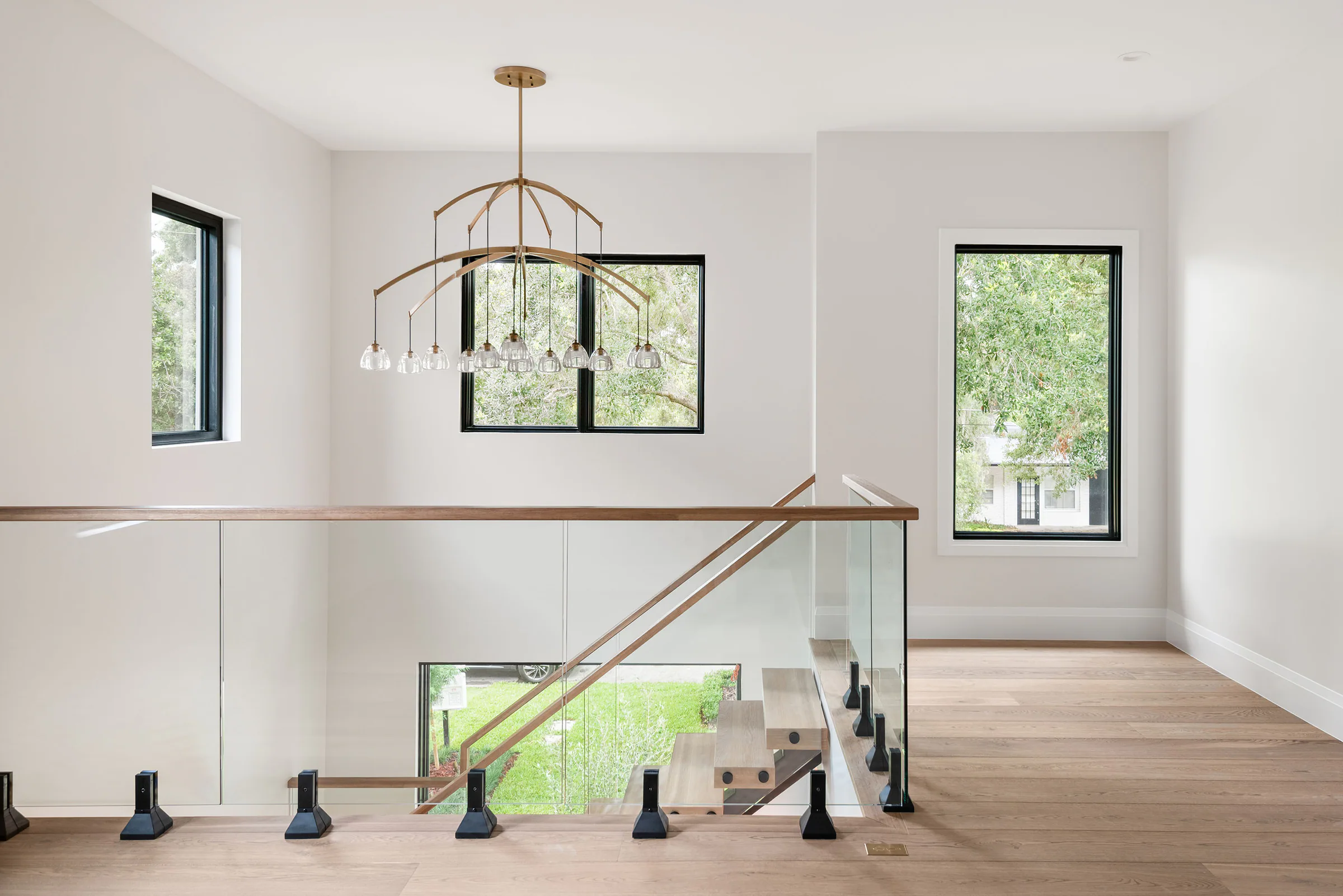 Upper landing with brass railing overlooking the stair.