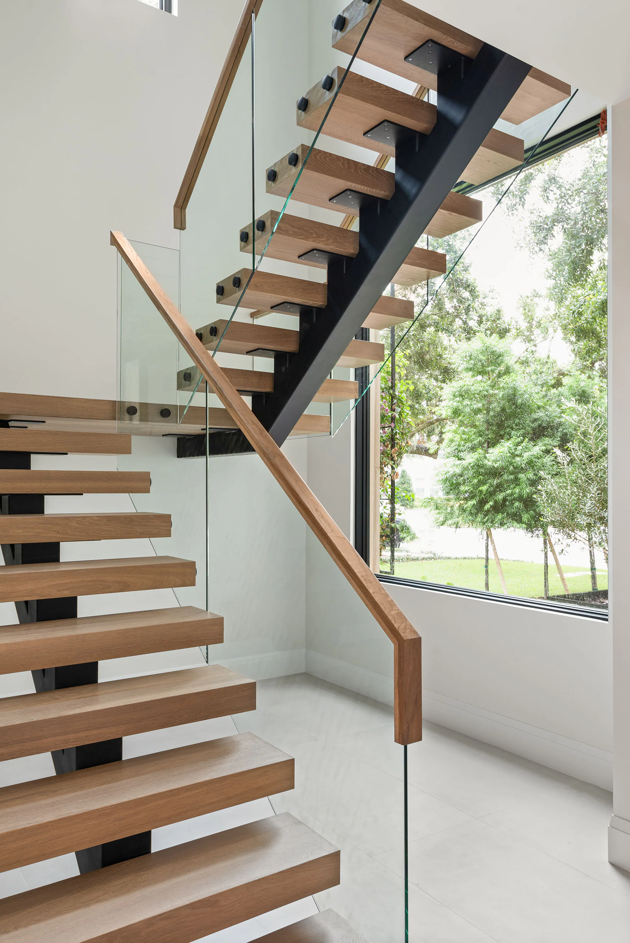 Floating timber stair with glass and dark metal balustrade.