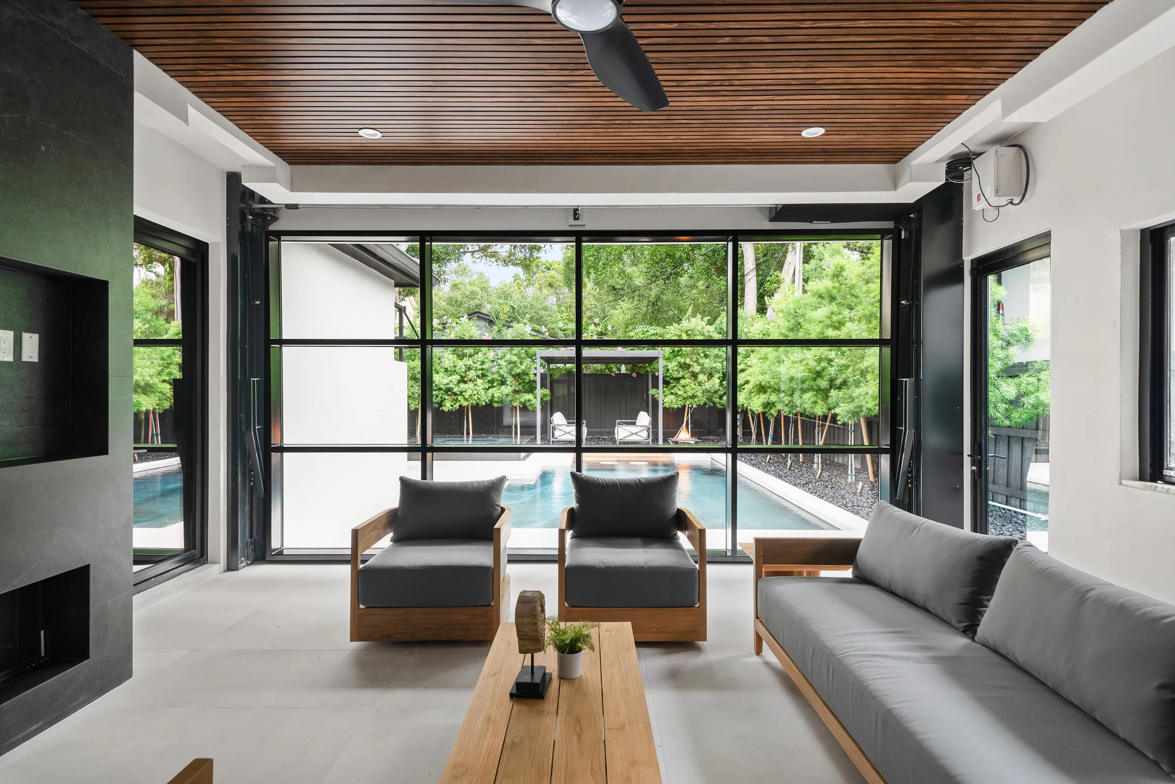 Covered seating area opening toward the pool. New Hampshire, a custom home by Rare Builders in Orlando.