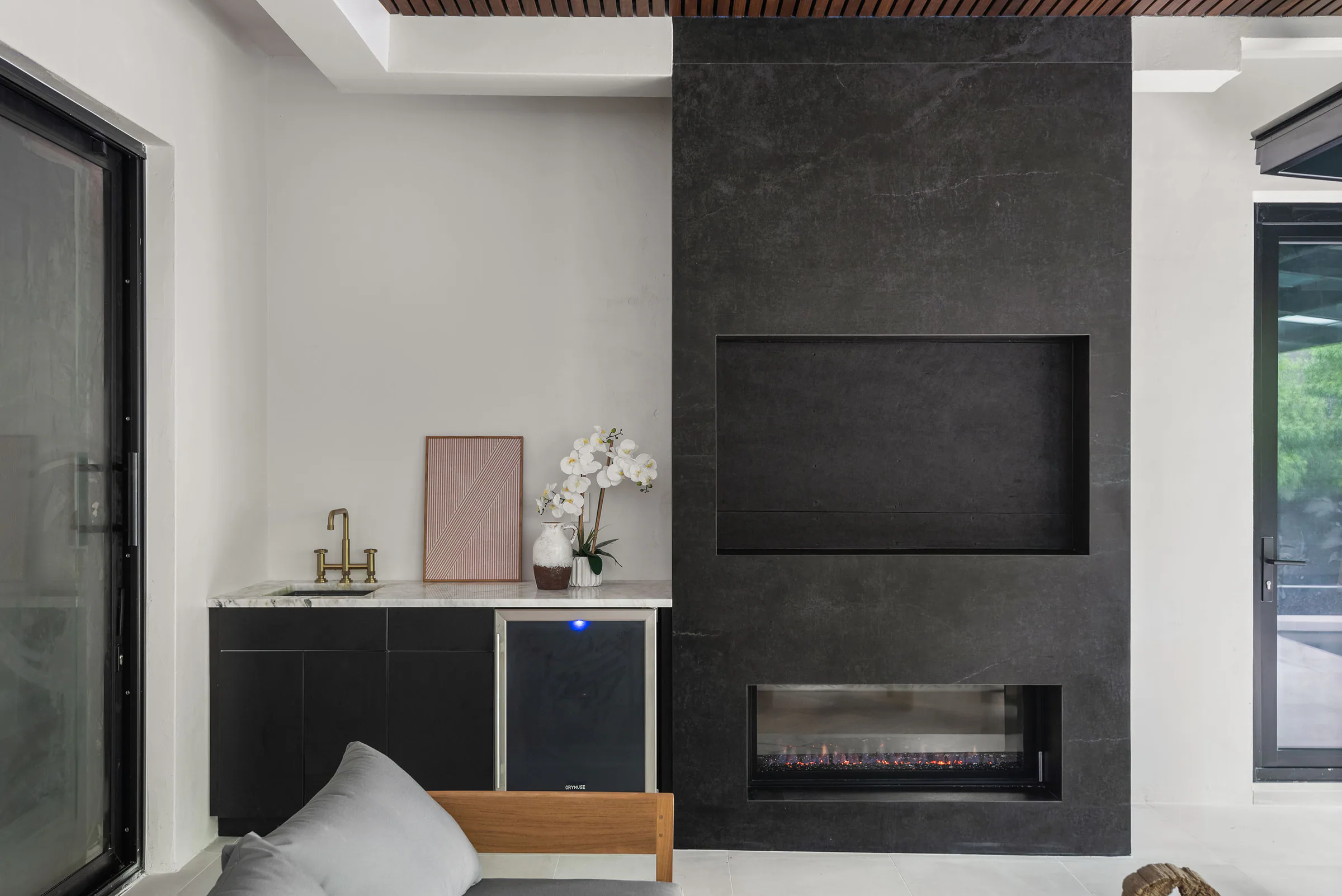 Dark fireplace wall and built-in bench in the outdoor room.