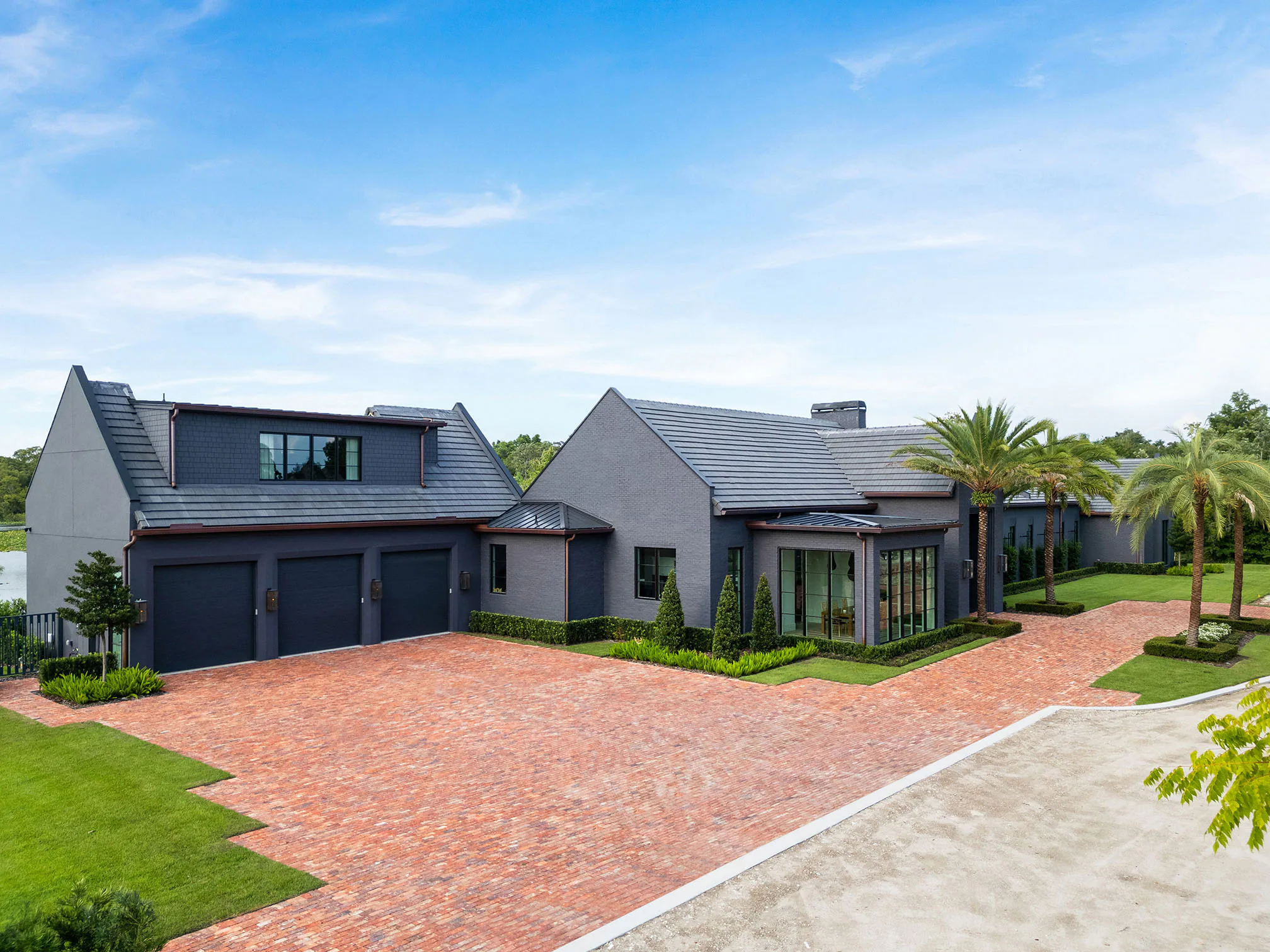 Elevated front view of Manor with its gabled roofline, garage court and brick paving.