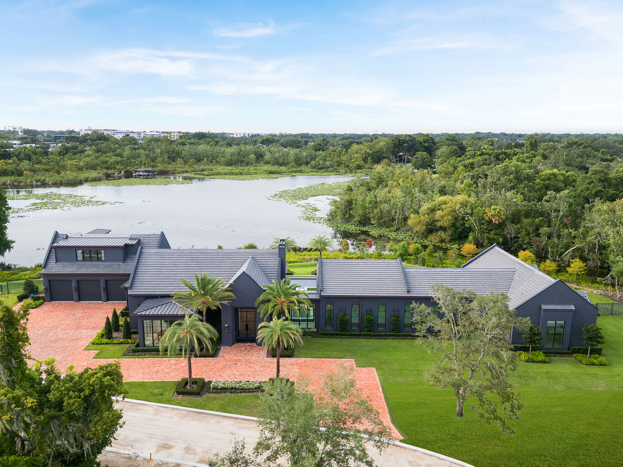 Aerial view of Manor, the brick arrival court and the lake beyond the rear lawn.