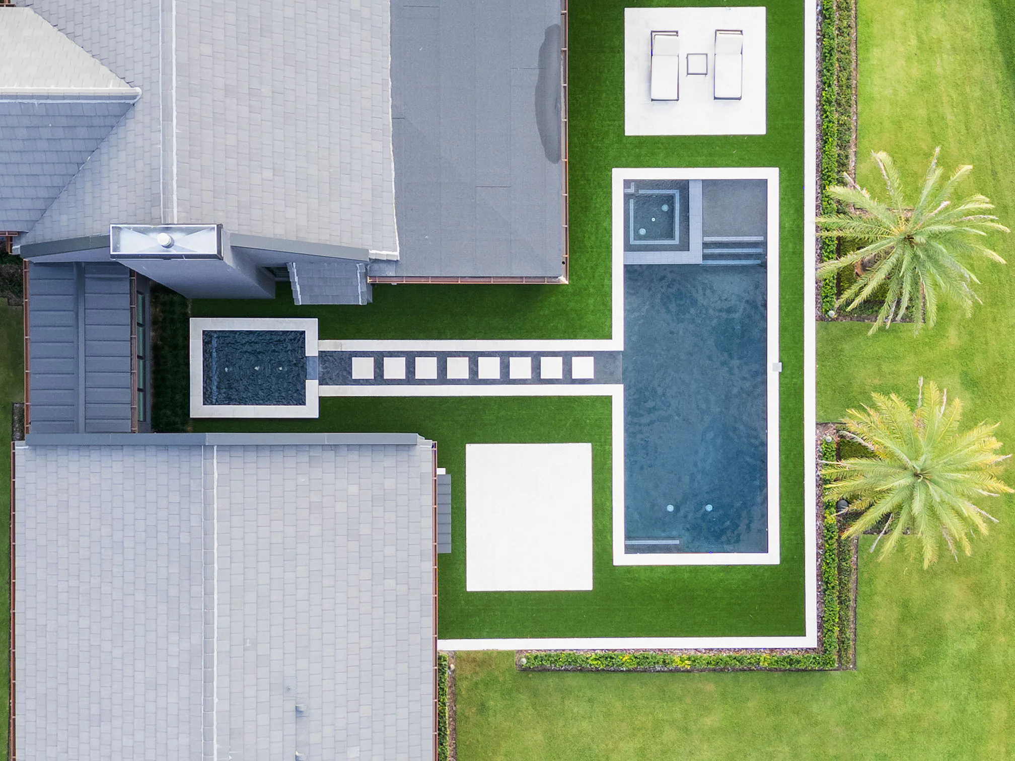 Straight-down aerial view of Manor, the pool terrace, lawn and brick drive.
