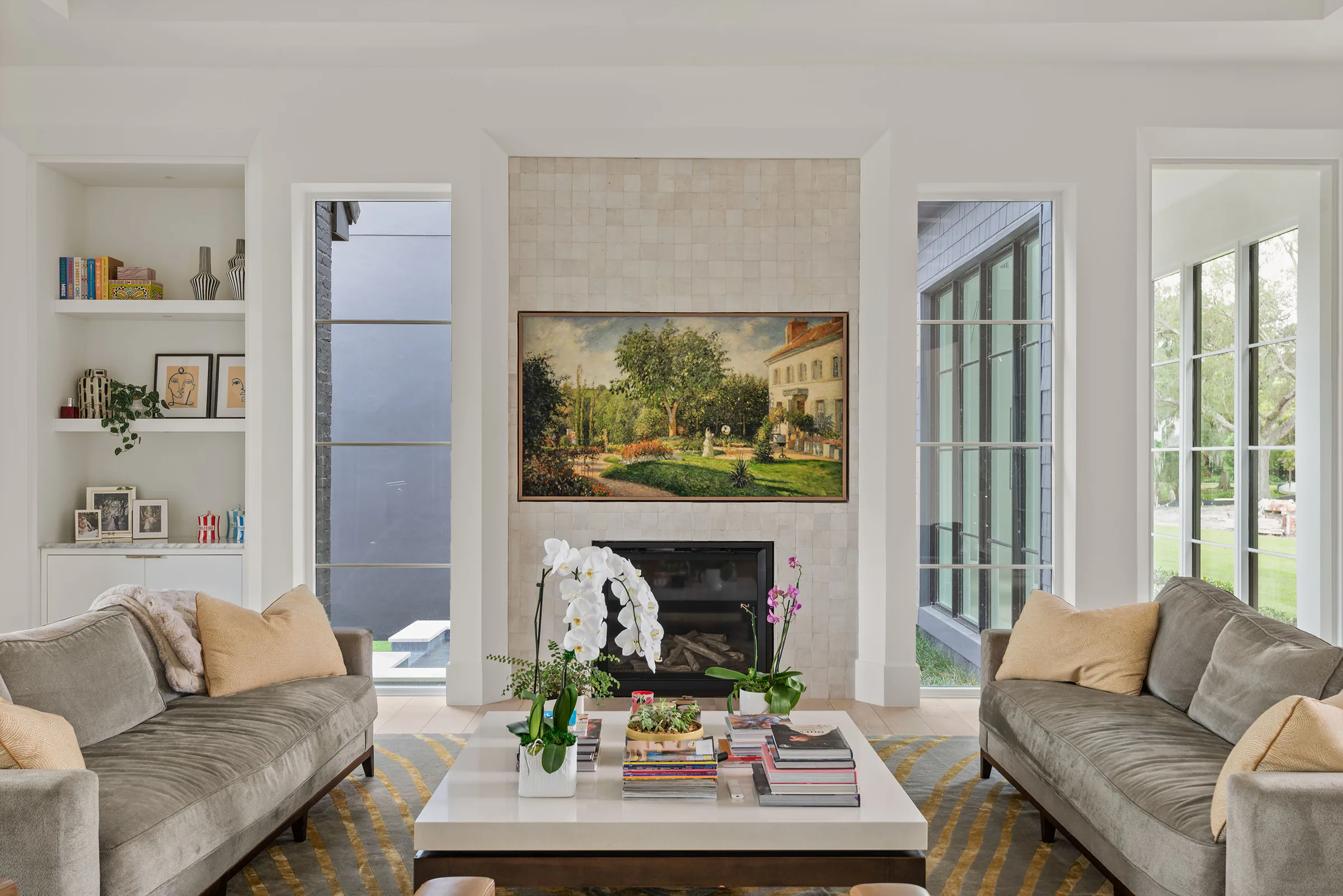 Living room detail with built-in shelving, a dark fireplace and pale oak flooring.