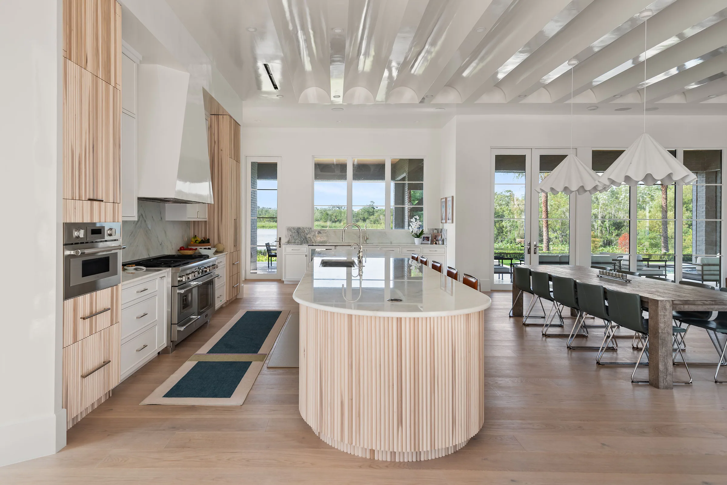 Kitchen view centered on the curved wood island and the dining area beyond.