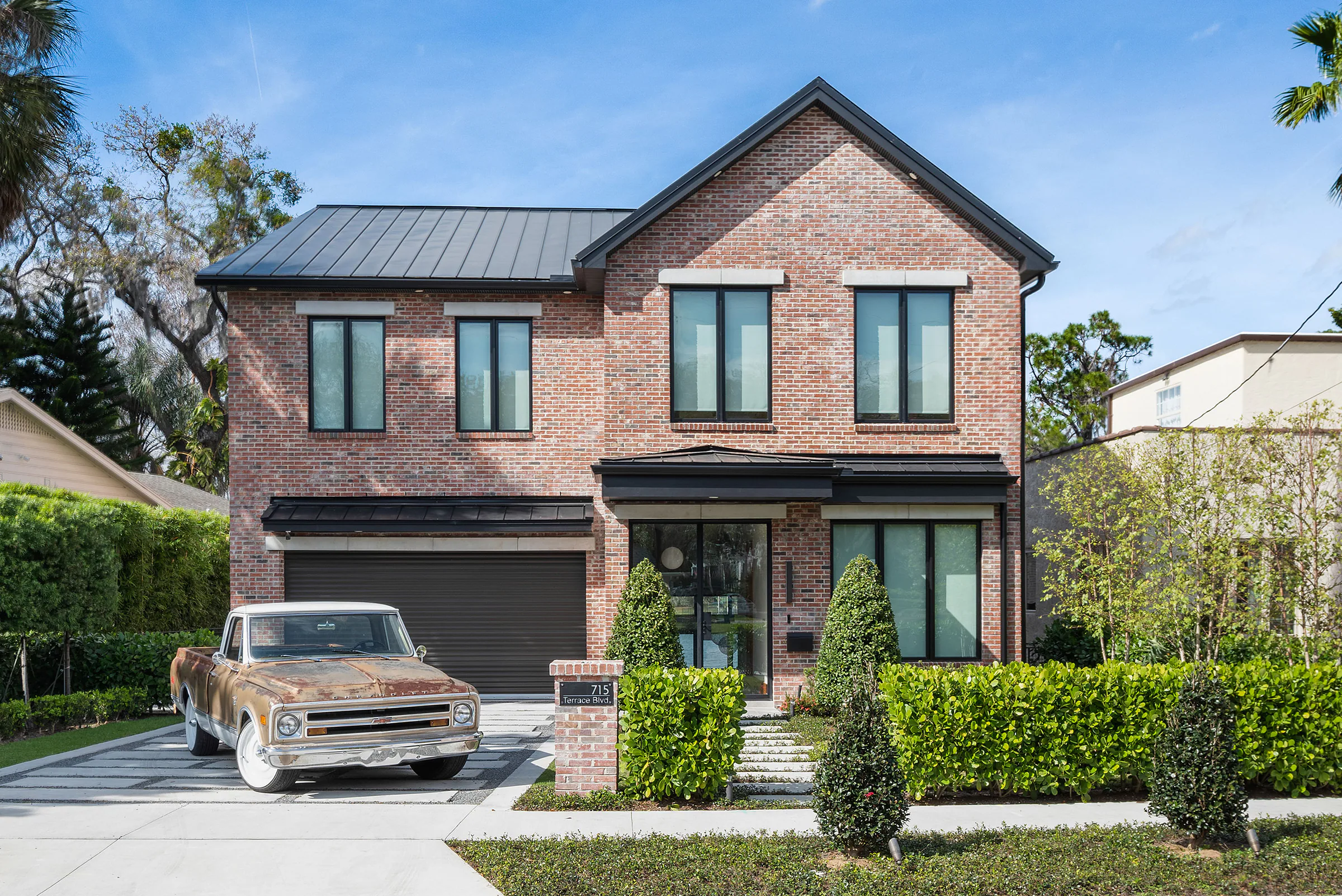 Red brick front elevation with a vintage vehicle on the drive.