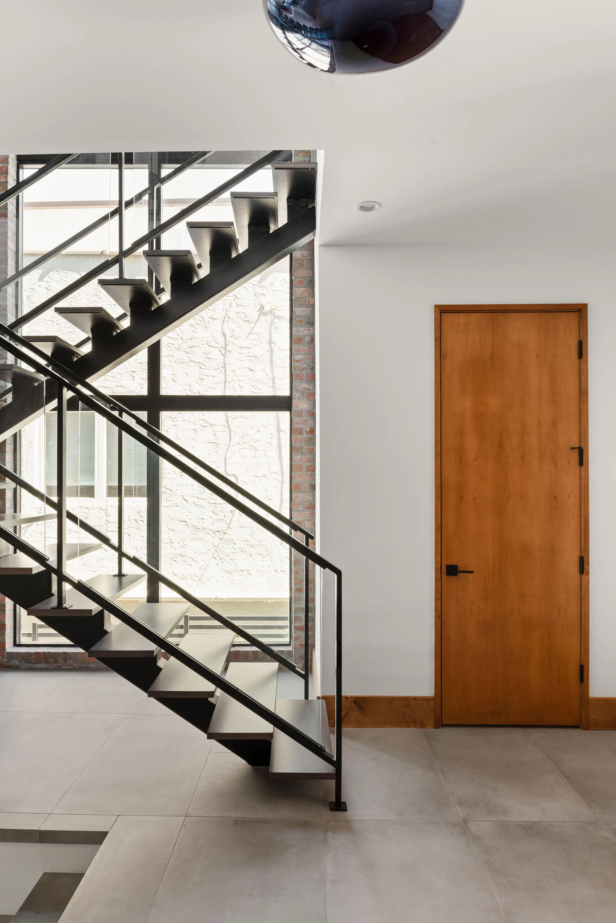 Entry hall with an open steel stair and full-height garden doors.