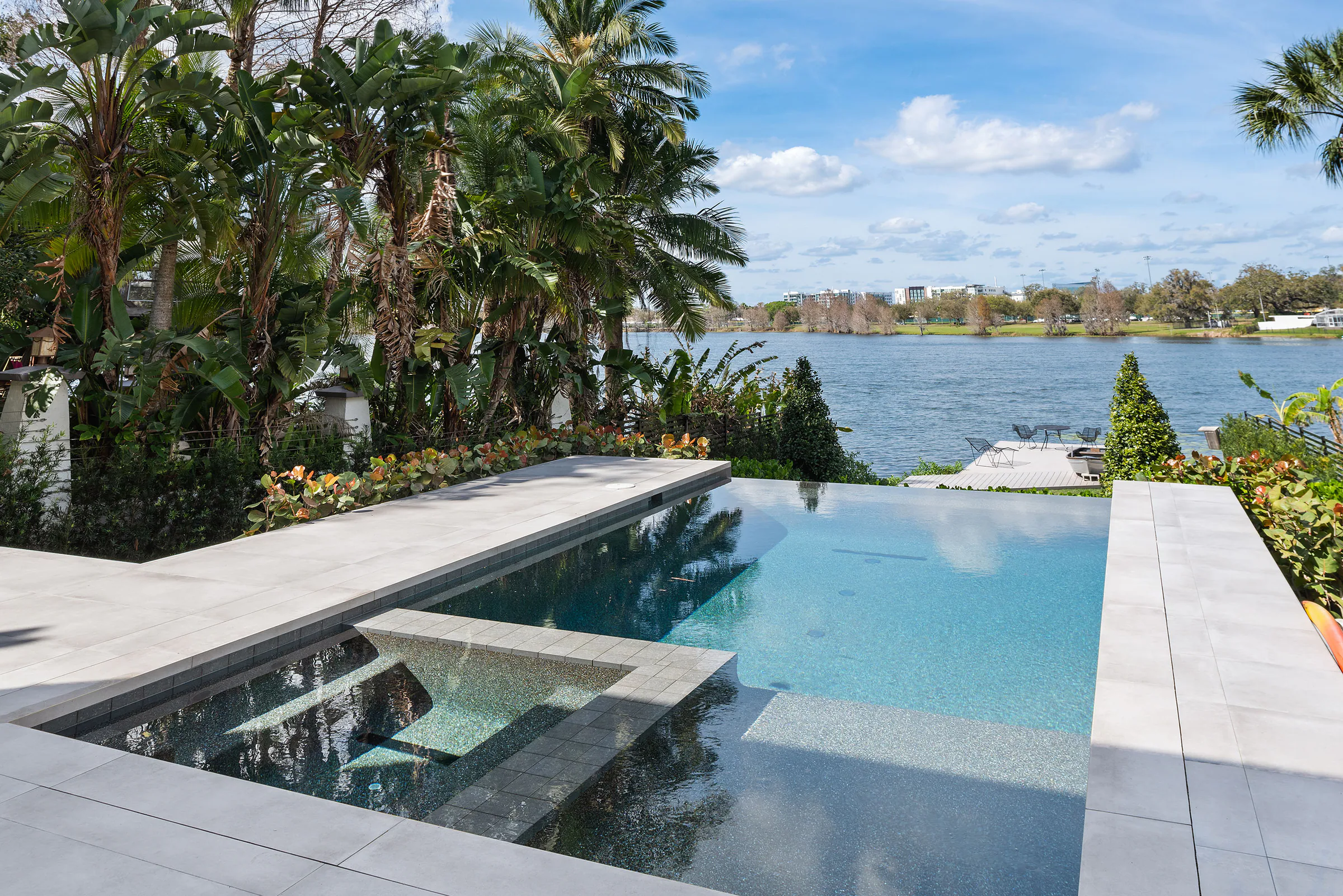 Infinity-edge pool and terrace facing the lake. Terrace, a custom home by Rare Builders in Orlando.