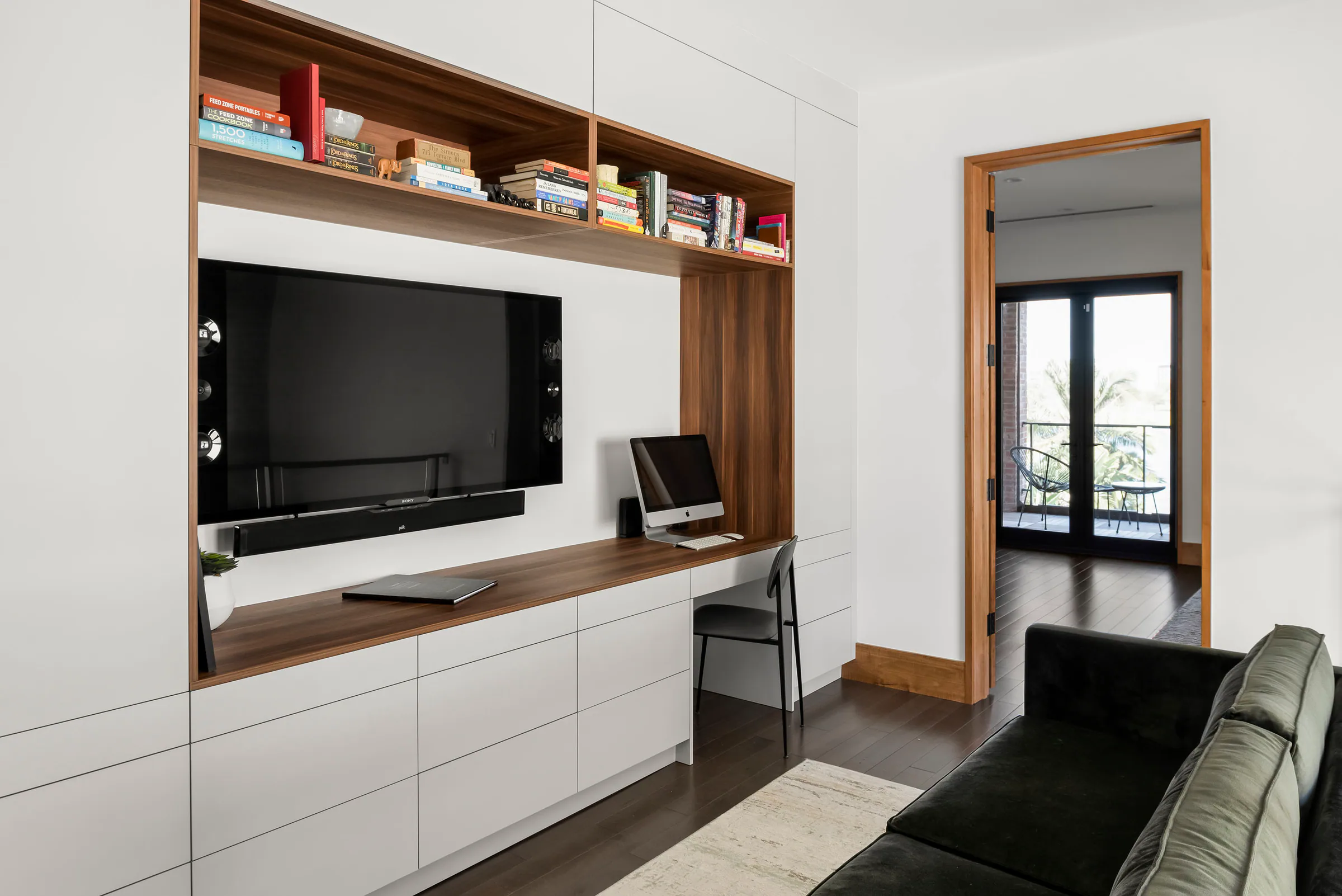 Bedroom with a low media cabinet and corner windows.