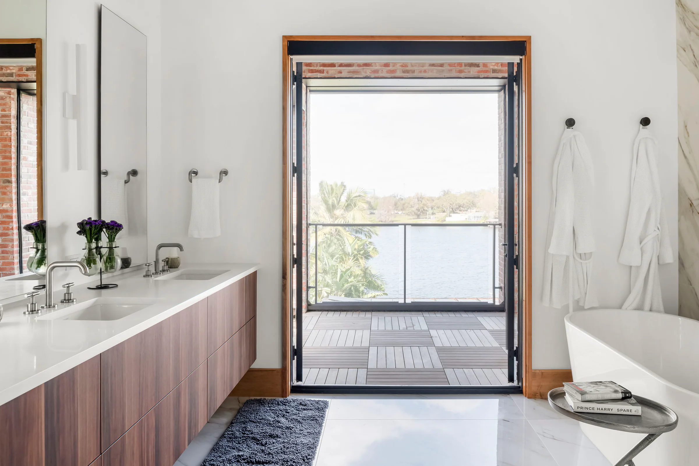 Bathroom with twin vanities and pale stone surfaces.
