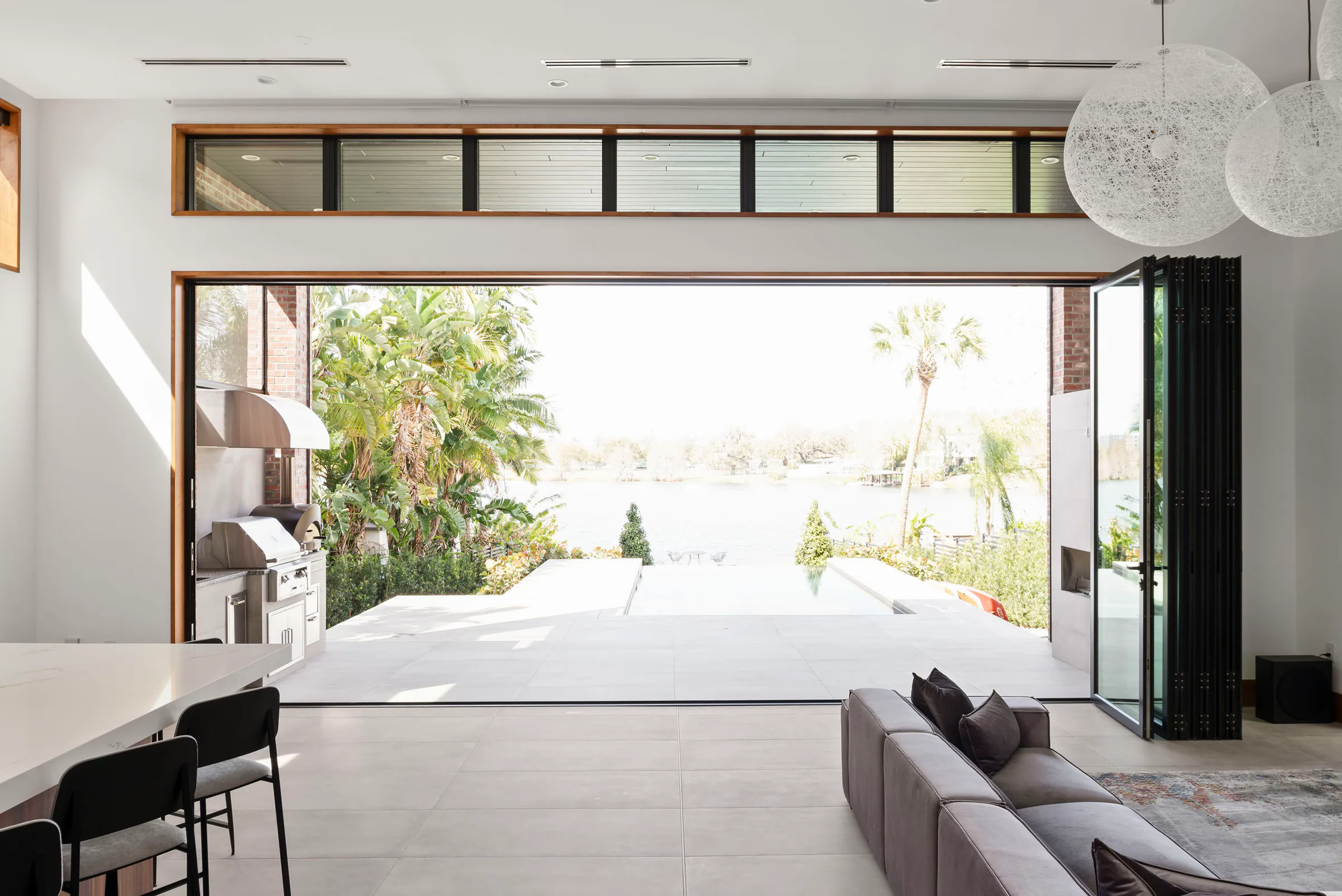 Bedroom opening through wide glass doors toward the lake.
