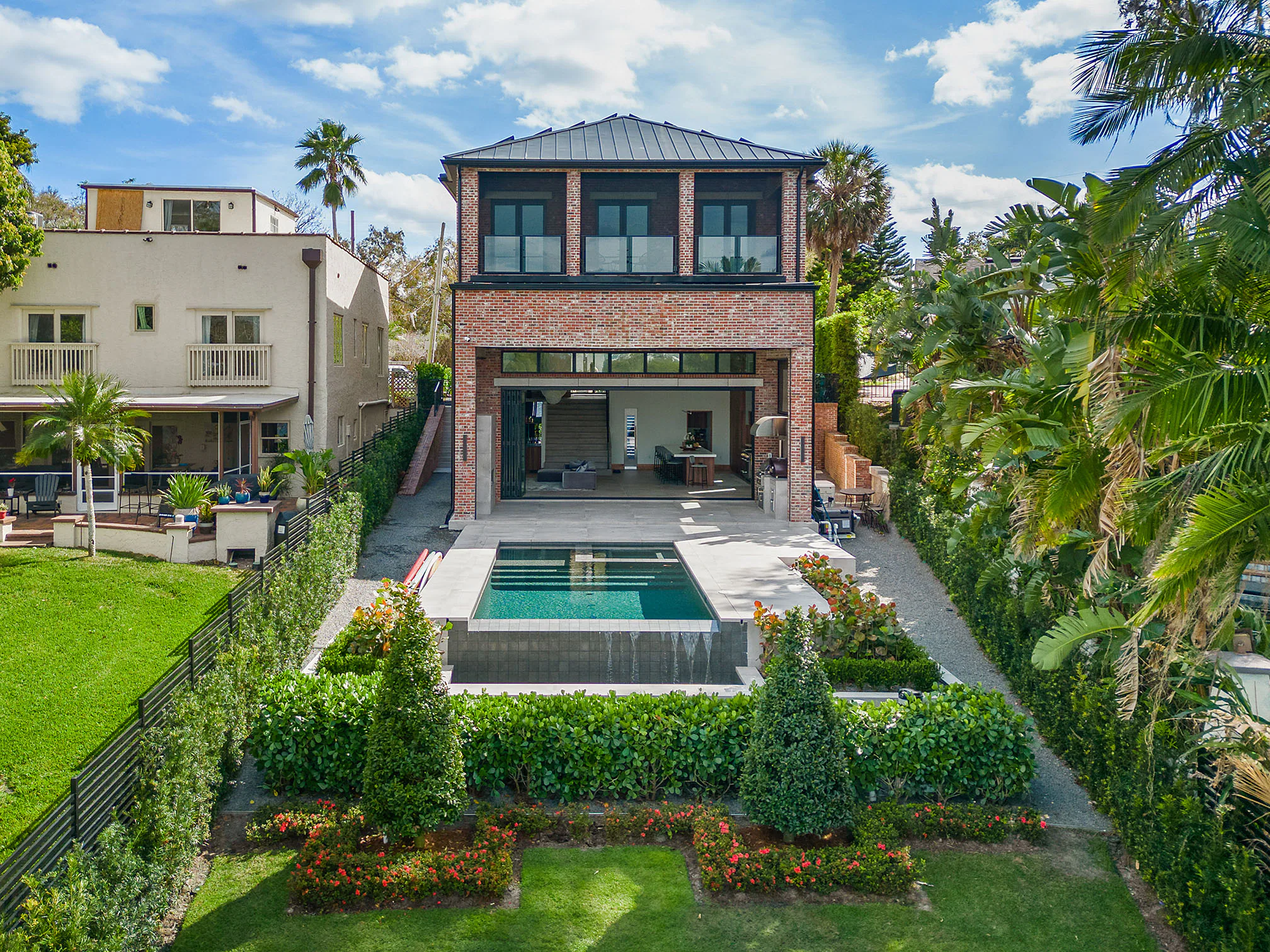Rear lawn and pool below the two-storey brick elevation.