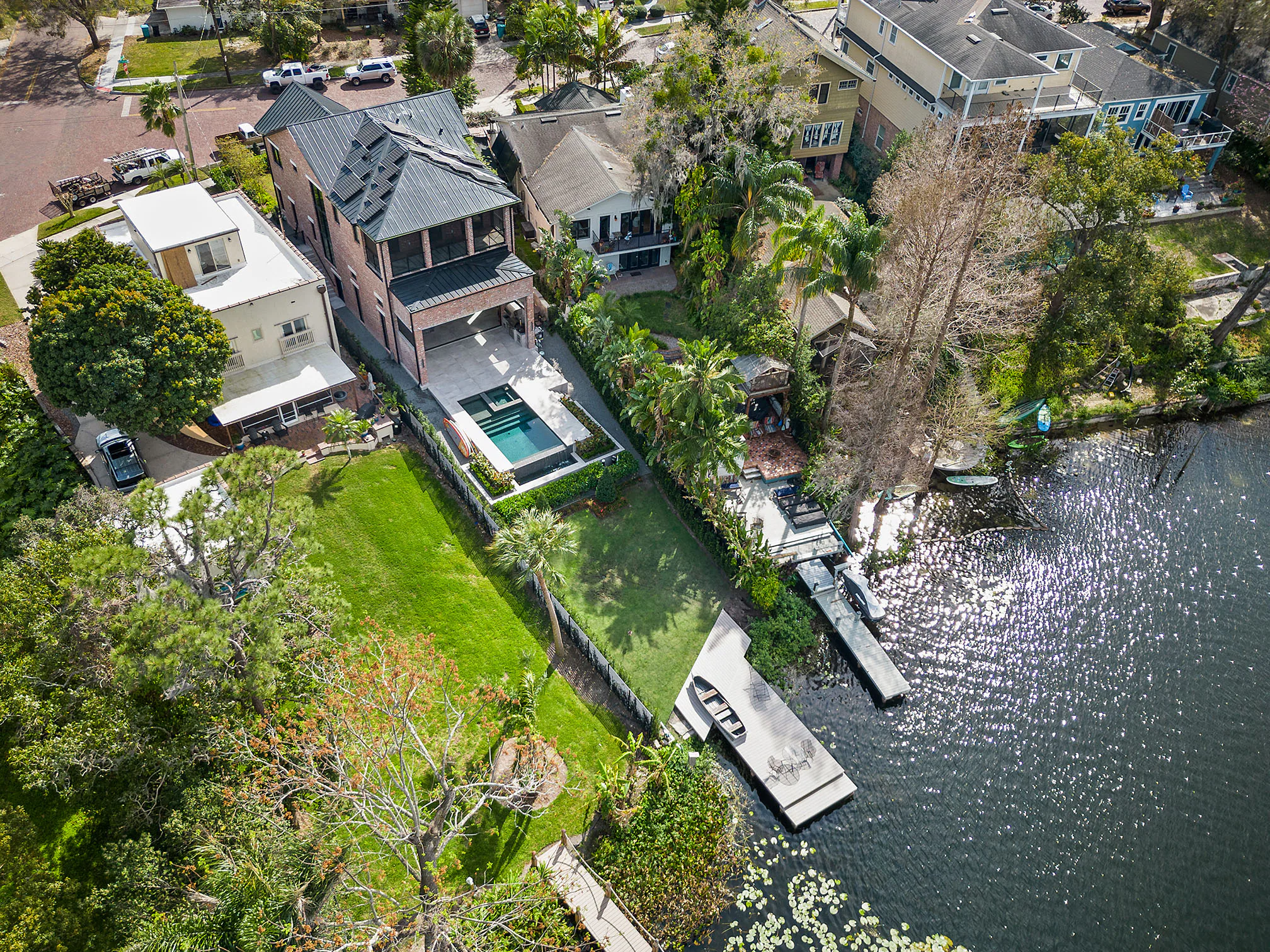 Aerial view of the residence, pool and neighboring tree canopy.